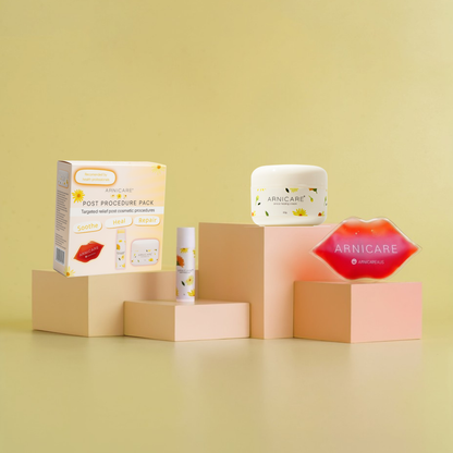 A post-procedure skincare set by Arnicare on a pale yellow background, featuring a product box, a white cream jar, a lip balm tube, and a red lip-shaped item, arranged on peach-colored display blocks.