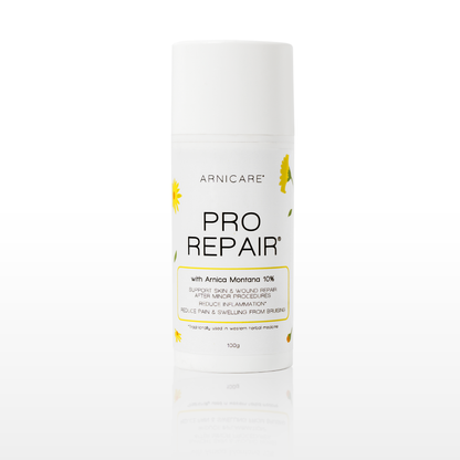 A white cylindrical cosmetic bottle of Arnicare Pro Repair with Amrica Montana 10% support skin and scar repair, featuring yellow daisy illustrations on a clean white background with a soft reflection.