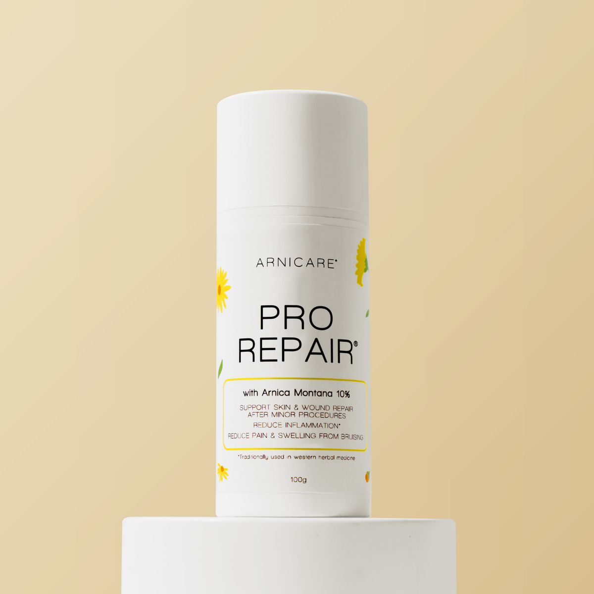 A white cylindrical ARNICARE Pro Repair cosmetic tube standing upright on a white pedestal against a warm beige background.